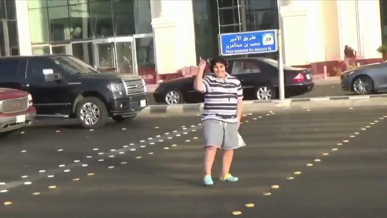 The boy dances in the street with his headphones on