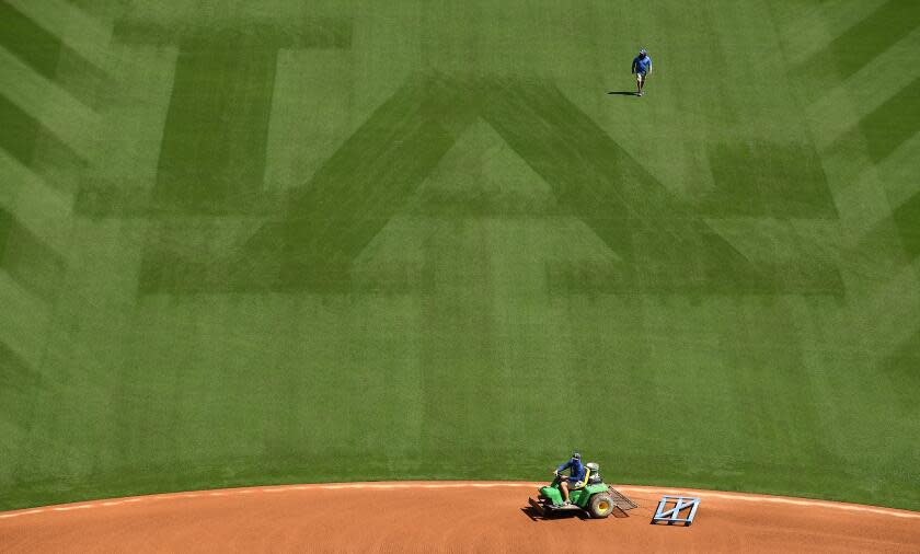 LOS ANGEL;ES, CALIFORNIA APRIL 8, 2021-Work crews prepare the field at Dodger Stadium for opening day Friday. (Wally Skalij/Los Angeles Times)