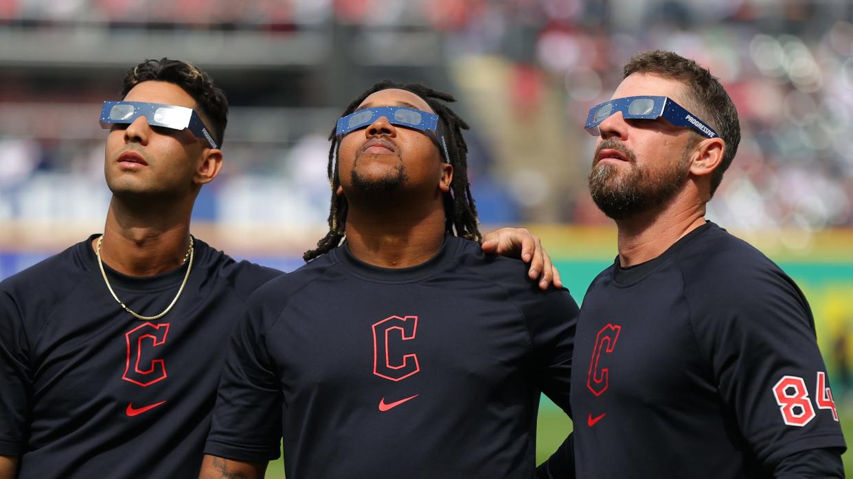 CLEVELAND, OHIO - APRIL 08: Brayan Rocchio #4, José Ramírez #11 and J.T. Maguire #84 of the Cleveland Guardians look up at the total solar eclipse before the home opener against the Chicago White Sox at Progressive Field on April 08, 2024 in Cleveland, Ohio. Cleveland is in the 