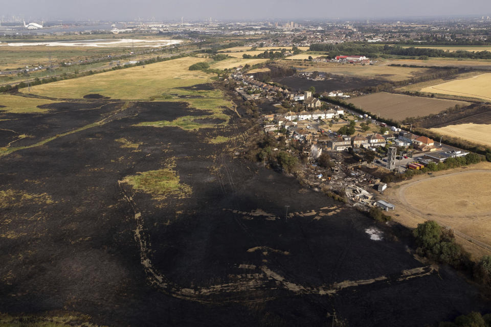 The scene after a blaze in the village of Wennington, east London, Wednesday July 20, 2022. Britain shattered its record for highest temperature ever registered Tuesday amid a heat wave that has seared swaths of Europe, as the U.K.'s national weather forecaster said such highs are now a fact of life in a country ill-prepared for such extremes. (Aaron Chown/PA via AP)