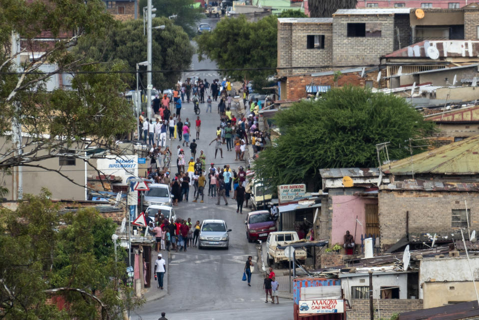 Residents of the densely populated Alexandra township east of Johannesburg gather in the streets Friday, March 27, 2020. South Africa went into a nationwide lockdown for 21 days in an effort to mitigate the spread to the coronavirus, but in Alexandra, many people were gathering in the streets disregarding the lockdown. The new coronavirus causes mild or moderate symptoms for most people, but for some, especially older adults and people with existing health problems, it can cause more severe illness or death.(AP Photo/Jerome Delay)