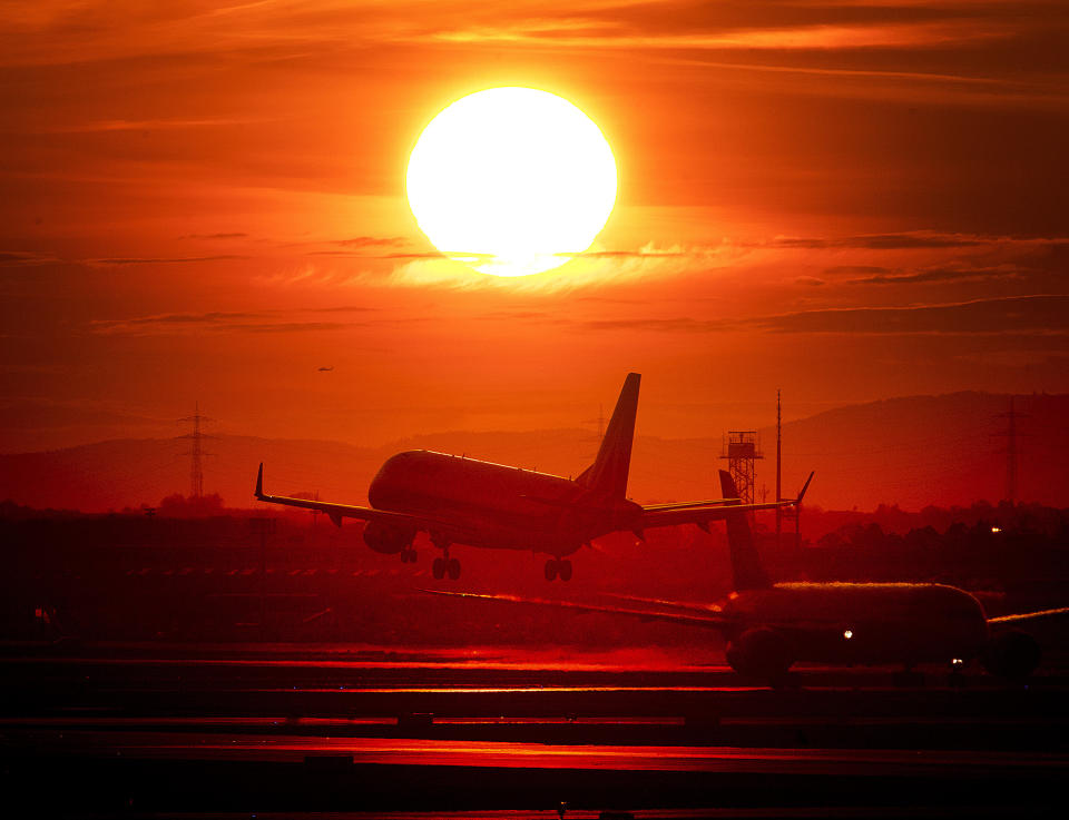 In this Wednesday, March 20, 2019 file photo an aircraft lands at the international airport in Frankfurt, Germany, as the sun sets. There is a small but growing movement in Sweden that's consciously shunning air travel because of its impact on the environment. (AP Photo/Michael Probst, file)