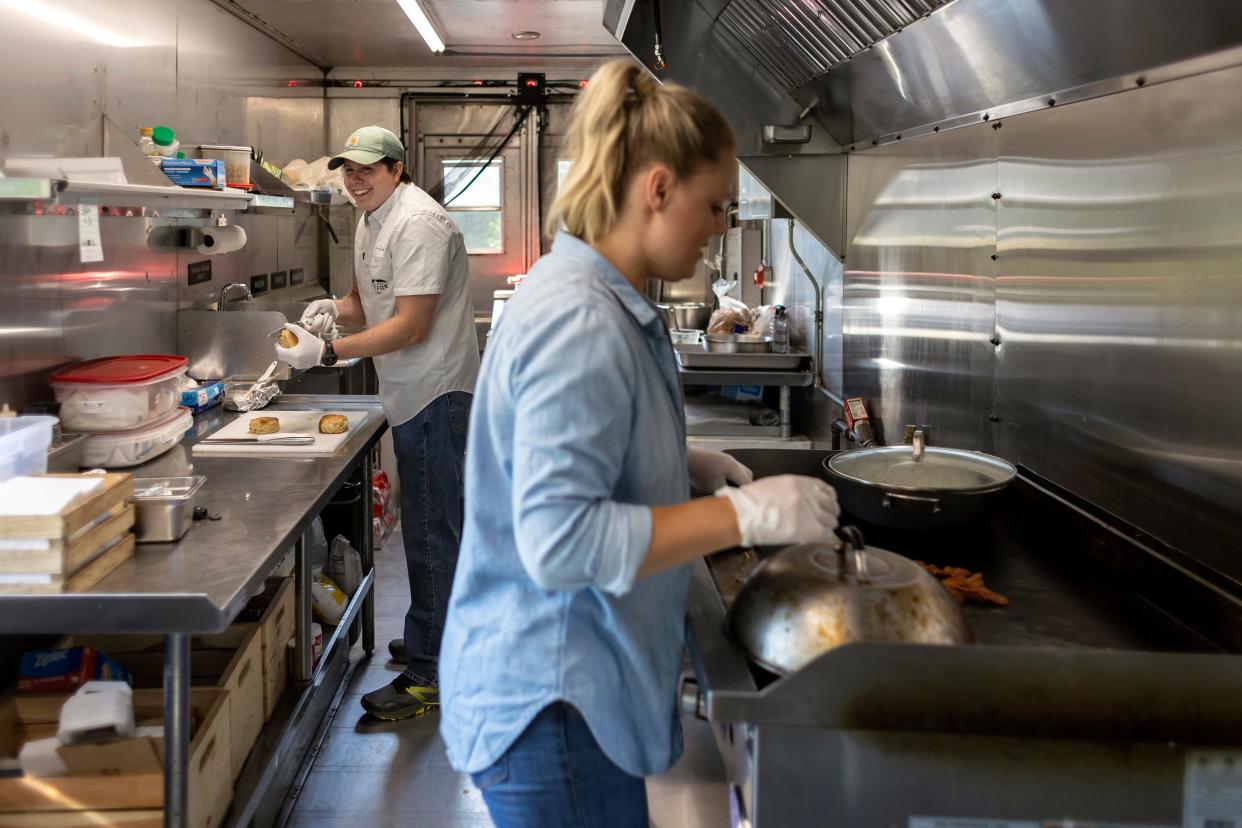 Husband and wife Cody Kilch and Katie House, owners and operators of Two Fox Farm curbside kitchen and market, cook breakfast for a customer inside their food truck on Thursday, May 19, 2022 in Athens. A new state law taking effect Sunday, Jan. 1, 2023, eases requirements for food trucks to operate outside their home counties.