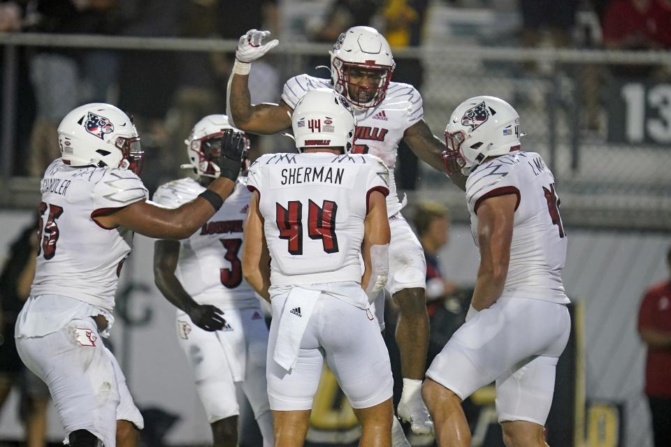 Louisville running back Tiyon Evans, top center, celebrates his touchdown against Central Florida with teammates, including Louisville tight end Francis Sherman (44), during the first half of an NCAA college football game, Friday, Sept. 9, 2022, in Orlando, Fla. (AP Photo/John Raoux)