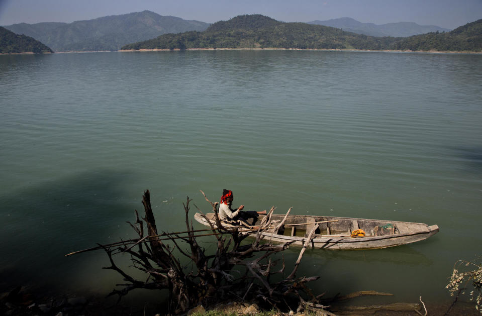 In this Saturday, Nov. 10, 2018 photo, Renkey Humtsoi, 48, hunter-turned-conservationist, rows a boat as he keeps a vigil over roosting Amur Falcons at Doyang reservoir near Pangti village, in the northeastern Indian state of Nagaland. The people in the area transformed from being hunters—killing up to 15,000 migratory Amur Falcons a day in 2012—to conservators - a feat that locals regard as one of the biggest conservation success stories in South Asia. (AP Photo/Anupam Nath)