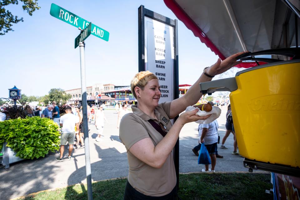 Jess Robertson adds ketchup and mustard to a corn dog at the Iowa State Fair.