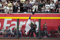 Colorado Rockies right fielder Jake Cave makes a leaping catch on a fly ball hit by Arizona Diamondbacks' Geraldo Perdomo during the sixth inning of a baseball game Thursday, March 28, 2024, in Phoenix. The Diamondbacks won 16-1. (AP Photo/Ross D. Franklin)