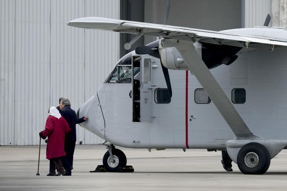 Members of human rights organizations walk alongside one of the planes that carried out "death flights," when detainees were tossed out into the sea during Argentina's last military dictatorship, on the tarmac of the Jorge Newbery international airport in Buenos Aires, Argentina, Saturday, June 24, 2023. The plane that had been located in the US arrived in Argentina's capital Saturday and will eventually be transferred to the the Museum of Memory set up in the former illegal detention center known as ESMA. (AP Photo/Natacha Pisarenko)