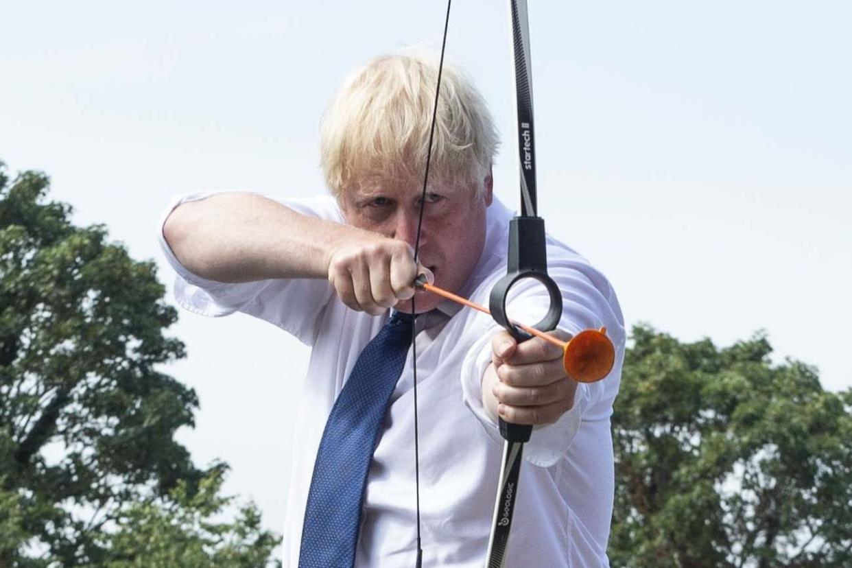 British prime minister Boris Johnson takes part in archery after sanitizing the equipment at Premier Education Summer Camp at Sacred Heart of Mary Girls' School in Upminster on August 10, 2020 in London, England: Getty Images