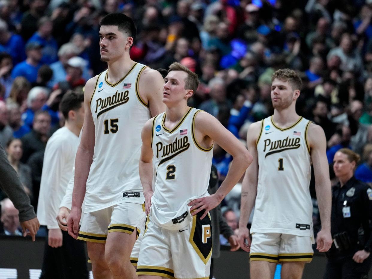 Purdue center Zach Edey, guard Fletcher Loyer and forward Caleb Furst walk off the court after loosing to Fairleigh Dickinson.