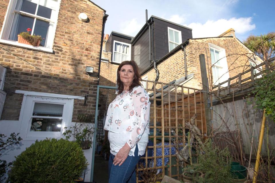 Janet Highland claims a new six-metre wall has been built across the property boundary, running 4cm on to her land