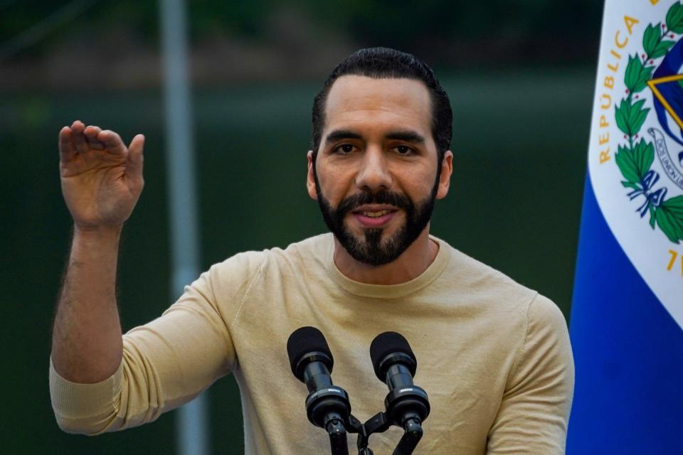 Bukele gesticula frente a la bandera de El Salvador