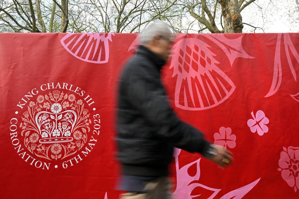 A pedestrian passes a partition displaying the Coronation Emblem near to Buckingham Palace in central London, on May 4, 2023.<span class="copyright">Sebastien Bozon—AFP/Getty Images</span>