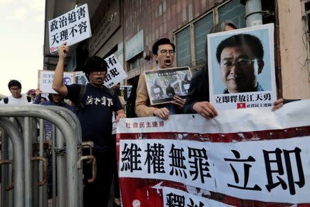 Pro-democracy demonstrators hold up portraits of Chinese disbarred lawyer Jiang Tianyong, demanding his release, during a demonstration outside the Chinese liaison office in Hong Kong, China December 23, 2016. REUTERS/Tyrone Siu