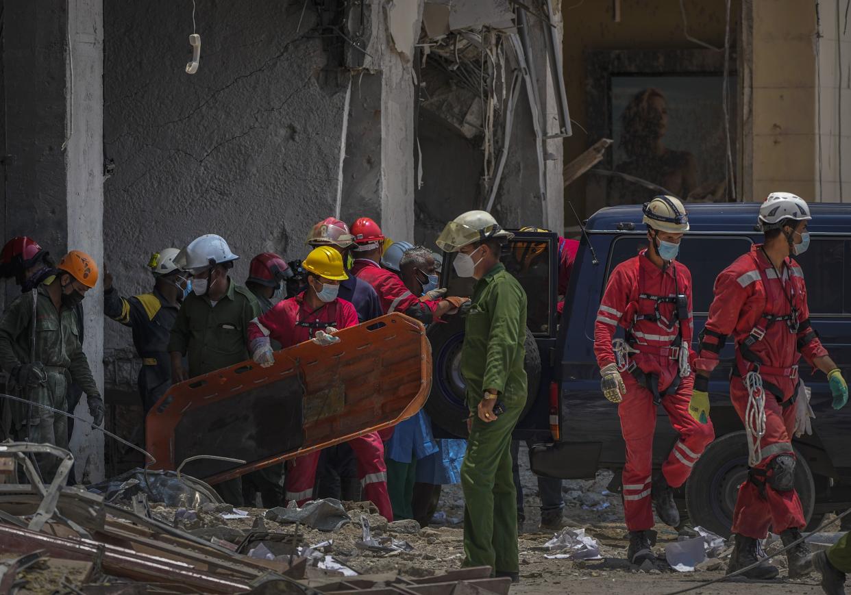 A member of a rescue team carries a stretcher after recovering a body from the rubble and loading it into a coroner´s vehicle, at the site of a deadly explosion that destroyed the five-star Hotel Saratoga in Old Havana, Cuba, Monday, May 9, 2022. 