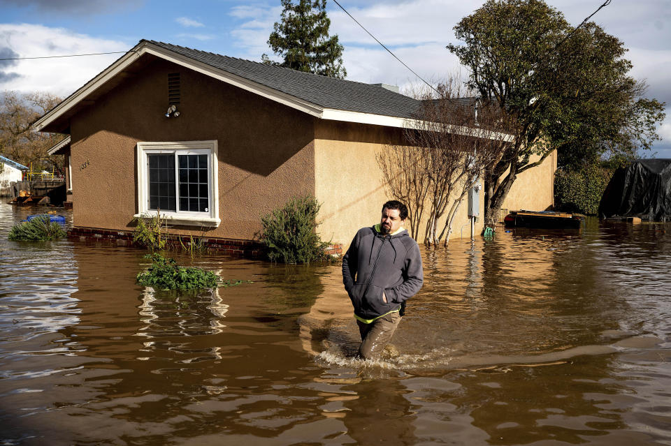Nick Enero wades through floodwaters while helping his brother salvage items from his Merced, Calif., home as storms continue battering the state on Jan. 10, 2023. The series of storms that have struck California have poured water on a state mired in a years-long drought. Experts say the precipitation will help relieve the drought somewhat. (AP Photo/Noah Berger)