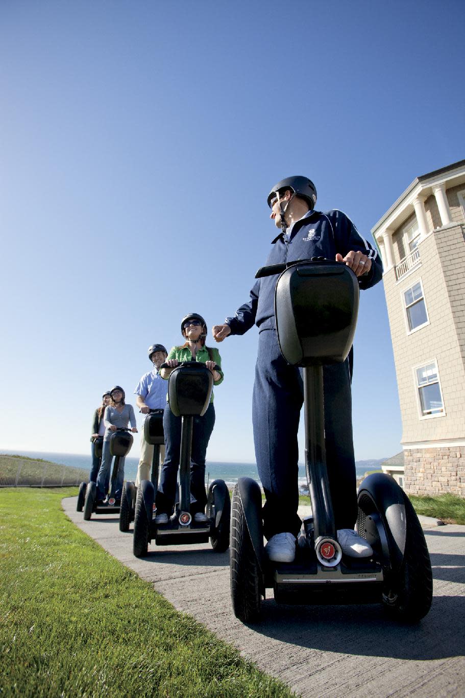 This 2010 photo provided by the Ritz-Carlton Half-Moon Bay shows a hotel recreational staff member leading a group of hotel guests on a Segway tour of the Coastal Trail in Half-Moon Bay, Calif., on the Pacific Ocean with the hotel property on a nearby cliff. A number of hotels offer Segway tours as a novel way to see their grounds and nearby scenic areas. (AP Photo/Ritz-Carlton)