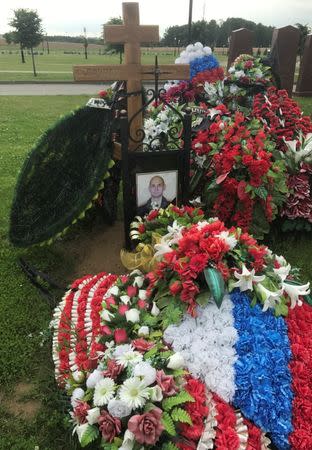 A portrait of Russian lieutenant colonel Gennady Perfilyev killed in Syria, is seen covering up his name at the grave at the Federal military memorial cemetery outside Moscow, Russia, July 4, 2017. REUTERS/Maria Tsvetkova