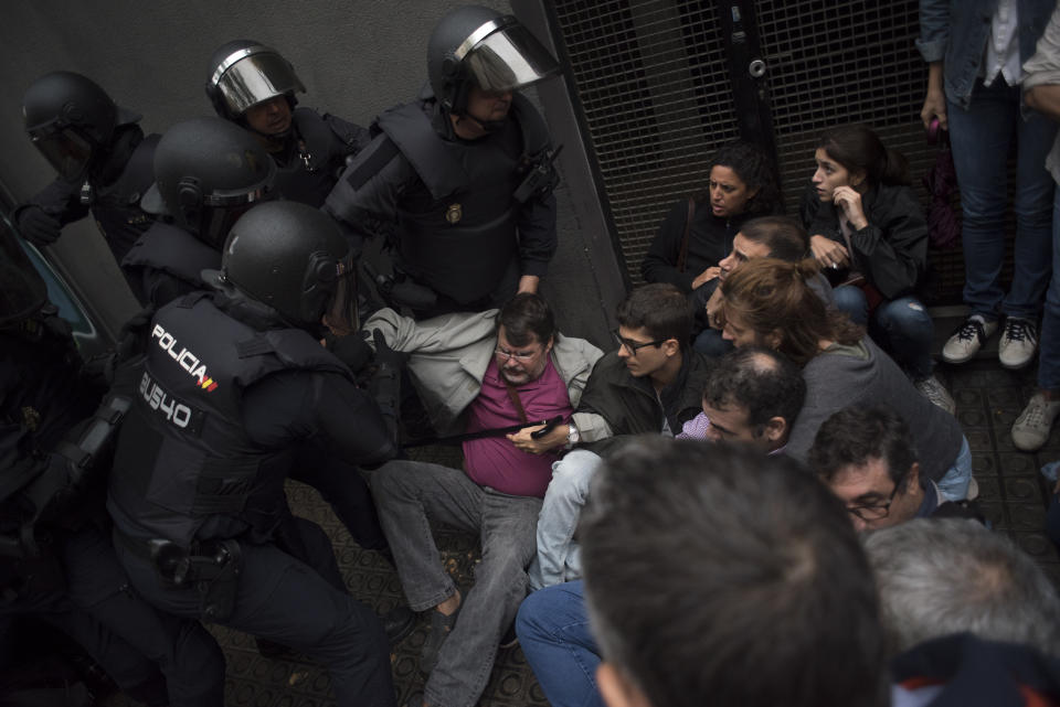 Riot police clash with members of the public outside a school being used as a polling station for the banned referendum.