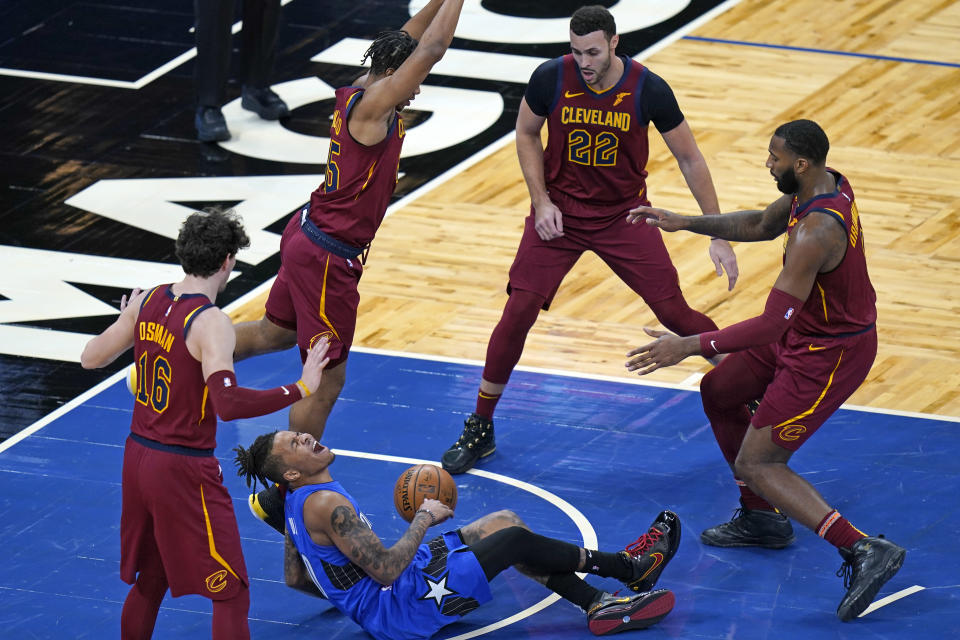 Orlando Magic guard Markelle Fultz, center, screams as he is injured while going up for a shot against Cleveland Cavaliers defense during the first half of an NBA basketball game, Wednesday, Jan. 6, 2021, in Orlando, Fla. (AP Photo/John Raoux)