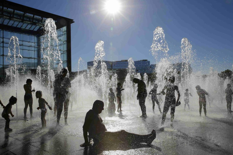 In Paris verschaffen sich Menschen bei warmen Sommertemperaturen in den Wasserfontänen eines Parks Abkühlung. (Bild: Pascal Rossignol/Reuters)