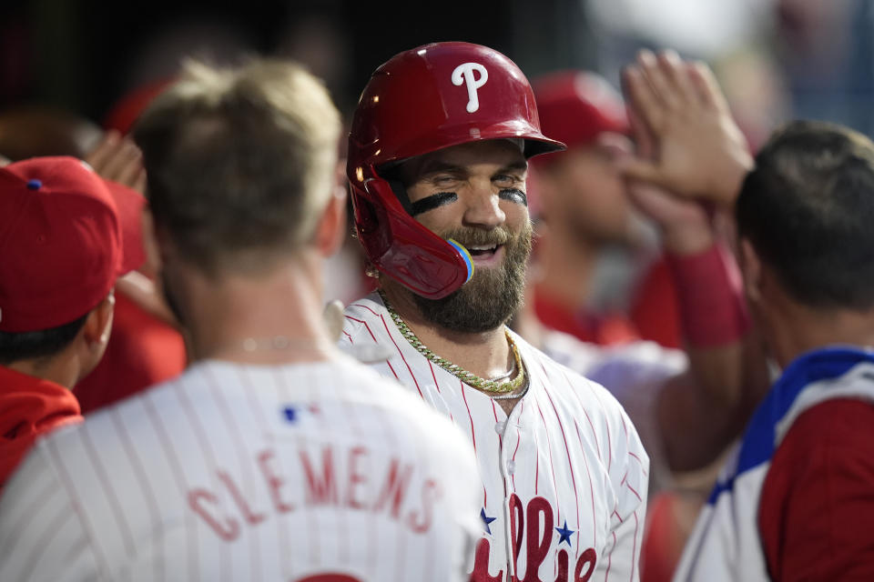 Philadelphia Phillies' Bryce Harper, center, celebrates with Kody Clemens and teammates after hitting a grand slam against Toronto Blue Jays pitcher Jose Berrios during the fourth inning of a baseball game, Tuesday, May 7, 2024, in Philadelphia. (AP Photo/Matt Slocum)