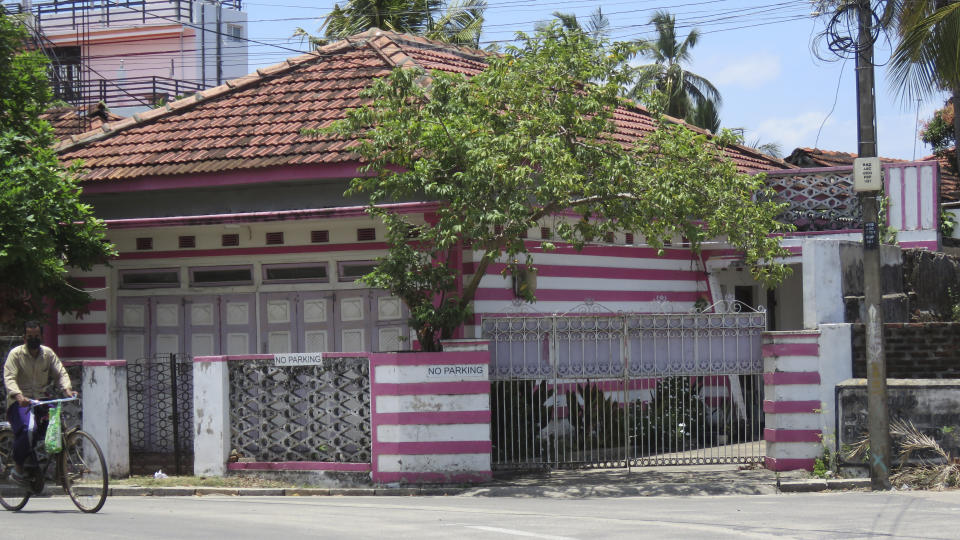 FILE - In this Sunday, Sept. 5, 2021, file photo, a man on a bicycle pedals past the family home of Ahamed Aathil Samsudeen, an Islamic State-inspired extremist, in the eastern Sri Lanka town of Kattankudy. Ahamed Aathil Samsudeen grabbed a kitchen knife from store shelf and begins stabbing shoppers while chanting “Allahu akbar” - meaning “God is great" at a Countdown supermarket on Sept. 3, 2021. (AP Photo/Kanagarasa Saravanan)