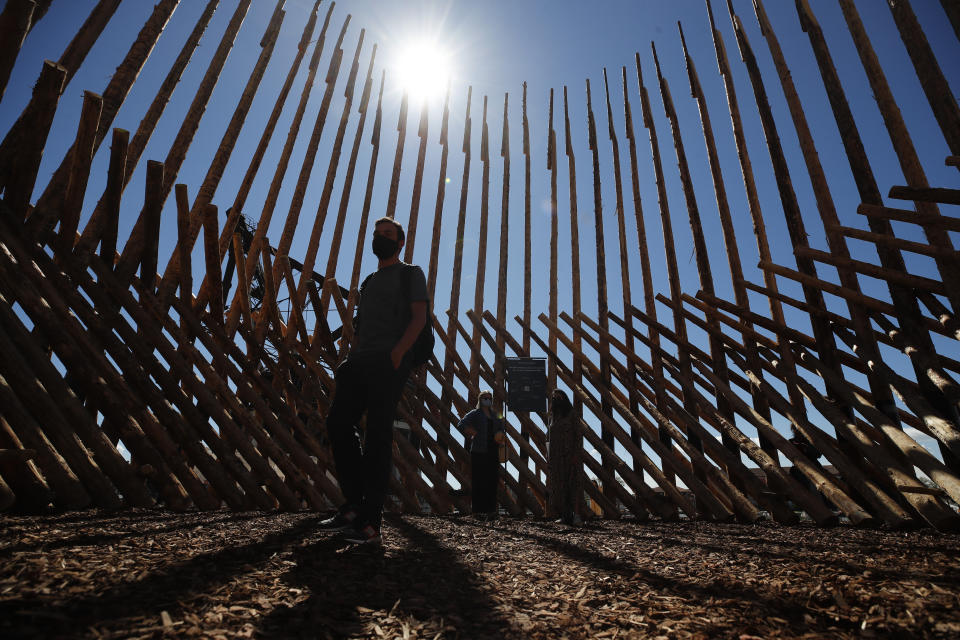 A visitor walks inside the installation "How we will leave together Chilean and Mapuche?" by Chilean studio Elemental, at the Biennale International Architecture, in Venice, Italy, Thursday, May 20, 2021. The 17th International Architecture Exhibition opens Saturday after a one-year pandemic delay, during which time architecture has emerged as one of the key disciplines in the global coronavirus response. (AP Photo/Alessandra Tarantino)