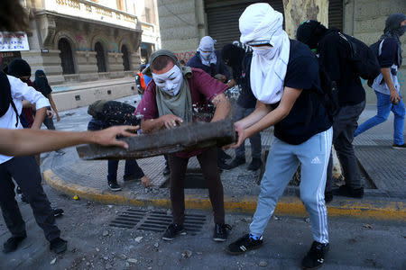 Demonstrators destroy concrete to throw its pieces against riot policemen during a protest calling for changes in the education system in Santiago, Chile April 11, 2017. REUTERS/Ivan Alvarado