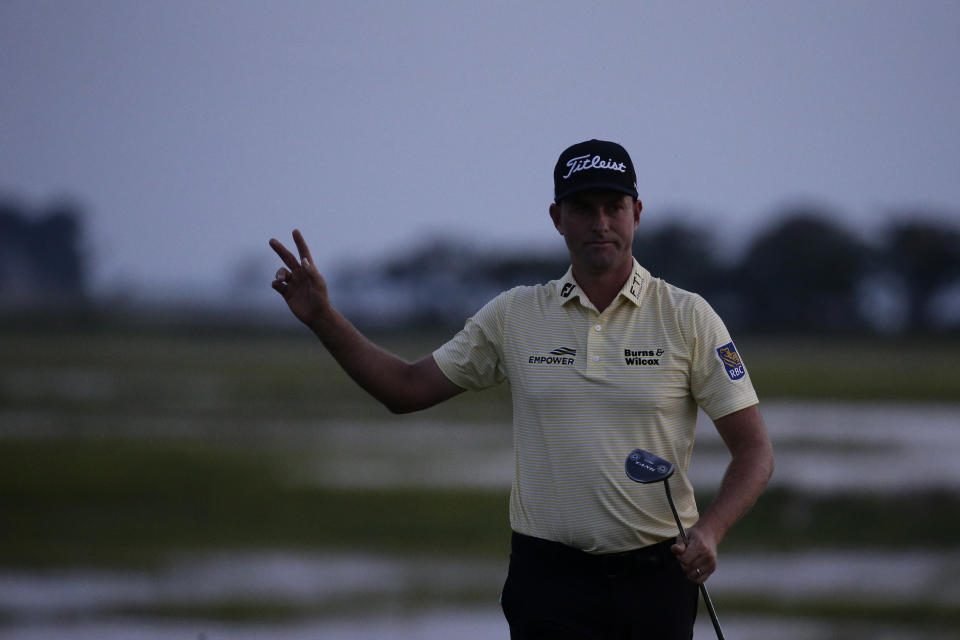 Webb Simpson waves as the sun disappears on the 18th green, on a course with no fans due to the COVID-19 pandemic, during the final round of the RBC Heritage golf tournament, Sunday, June 21, 2020, in Hilton Head Island, S.C. (AP Photo/Gerry Broome)
