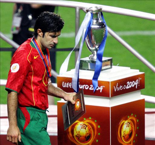 Portuguese captain Luís Figo walks past the trophy after receiving his runners up medal ,04 July 2004 at the Estadio da Luz in Lisbon, after the European Nations championship final football match between Portugal and Greece. Greece won 1-0.AFP PHOTO Vincenzo PINTO