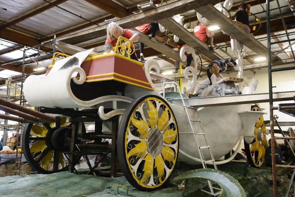 A group of volunteers work on a float ahead of next week's 128th Rose Parade Wednesday, Dec. 28, 2016, in Irwindale, Calif. (AP Photo/Jae C. Hong)