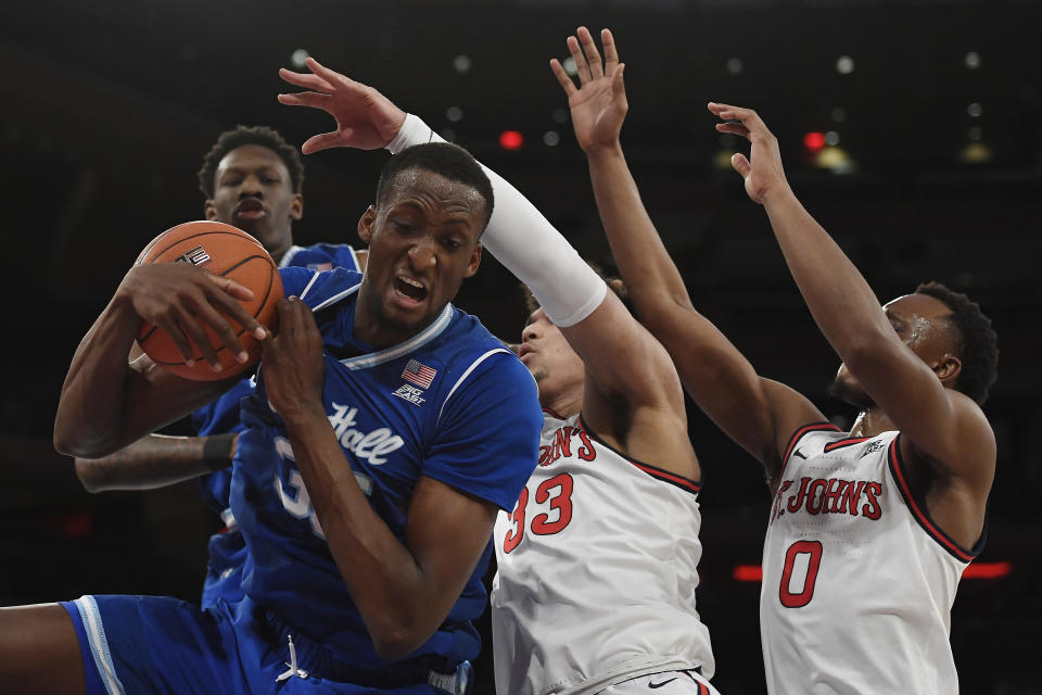 Seton Hall center Romaro Gill (35) catches a rebound against St. John's forward Ian Steere (33) and guard Mustapha Heron (0) during the first half of an NCAA college basketball game in New York, Saturday, Jan. 18, 2020. (AP Photo/Sarah Stier)
