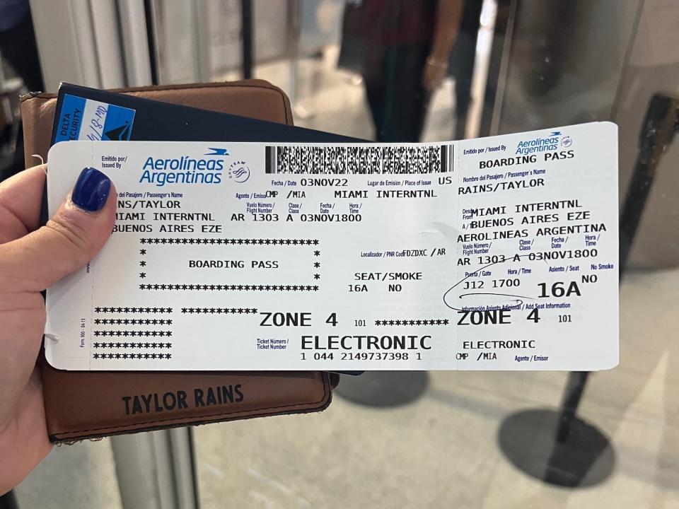 The author holding her passport and boarding pass.