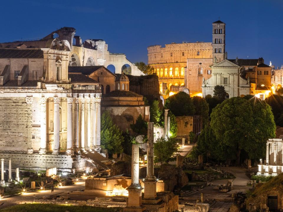 A view of Rome at night with the Colosseum in the background.