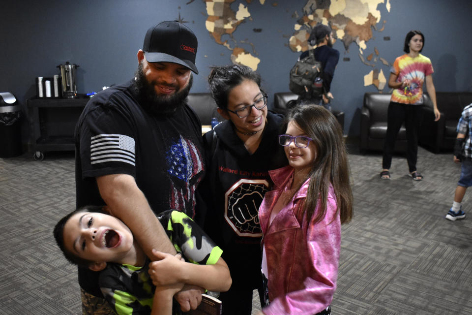 J.T. Smith, back left, and Virginia Smith talk with their children James, front left, and Crystal, right, at the Watford City Assembly of God church, Aug. 25, 2021, in Watford City, N.D. The family moved to McKenzie County from Texas after J.T. Smith got a job in the North Dakota's booming oil fields. (AP Photo/Matthew Brown)