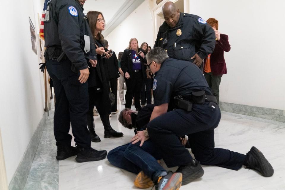 Capitol Police pin Manuel Oliver to the floor outside the committee room (AP)