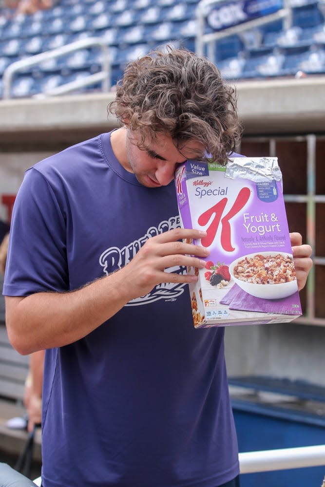 Blue Wahoos pitcher Zack Weiss uses a homemade pinhole projector to safely watch the solar eclipse at Blue Wahoos Stadium on Monday, August 21, 2017.