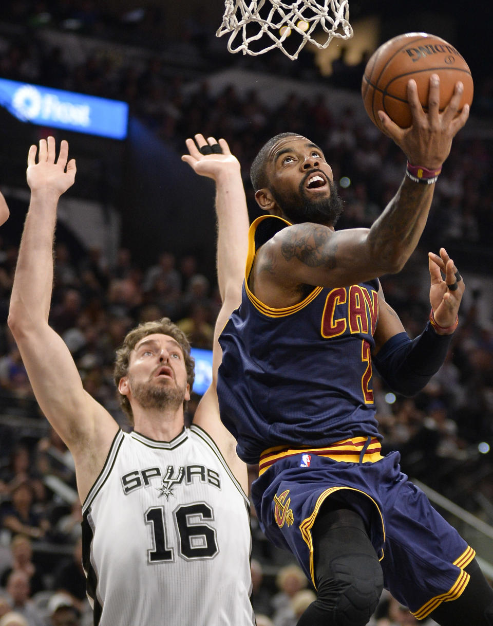 Cleveland Cavaliers guard Kyrie Irving, right, shoots as San Antonio Spurs center Pau Gasol, of Spain, looks on during the first half of an NBA basketball game, Monday, March 27, 2017, in San Antonio. (AP Photo/Darren Abate)
