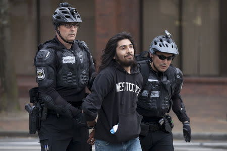 Police detain a demonstrator during an anti-capitalist protest in Seattle, Washington, May 1, 2015. REUTERS/David Ryder