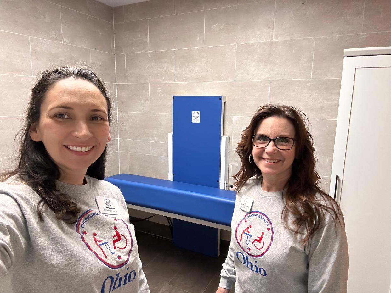 Kim Boulter (left) and Jennifer Corcoran, co-chapter leaders of advocacy group Changing Spaces Ohio, in front of a universal changing table. They advocate for more appropriate, safe and private changing tables for children and adults who need them.