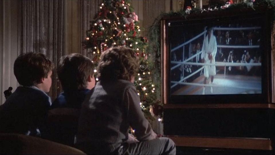 Rocky's son and friends watch Rocky's fight against Drago on TV with a Christmas tree nearby them in the room