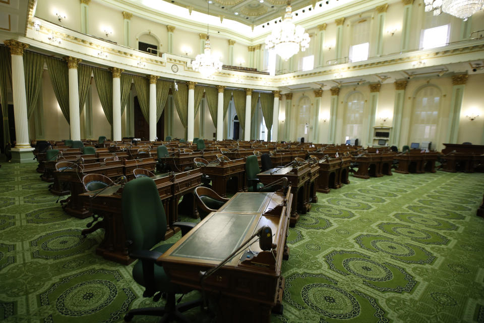 The state Assembly Chambers sits empty at the Capitol in Sacramento, Calif., Wednesday, March 18, 2020. In a precautionary effort to deal with the coronavirus, the Capitol and Legislative Office Building were closed to the public with only essential state workers and legislative employees allowed in until further notice, based on a "stay at home" directive issued by Sacramento County. (AP Photo/Rich Pedroncelli)