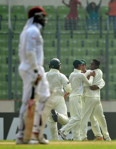 Bangladesh's Sohag Gazi (R) celebrates with teammates after the dismissal of West Indies cricketer Chris Gayle (L) during the first day of their first Test in Dhaka. The off-spinner opened the bowling attack and dismissed Gayle (24) and Darren Bravo (14) in his first spell