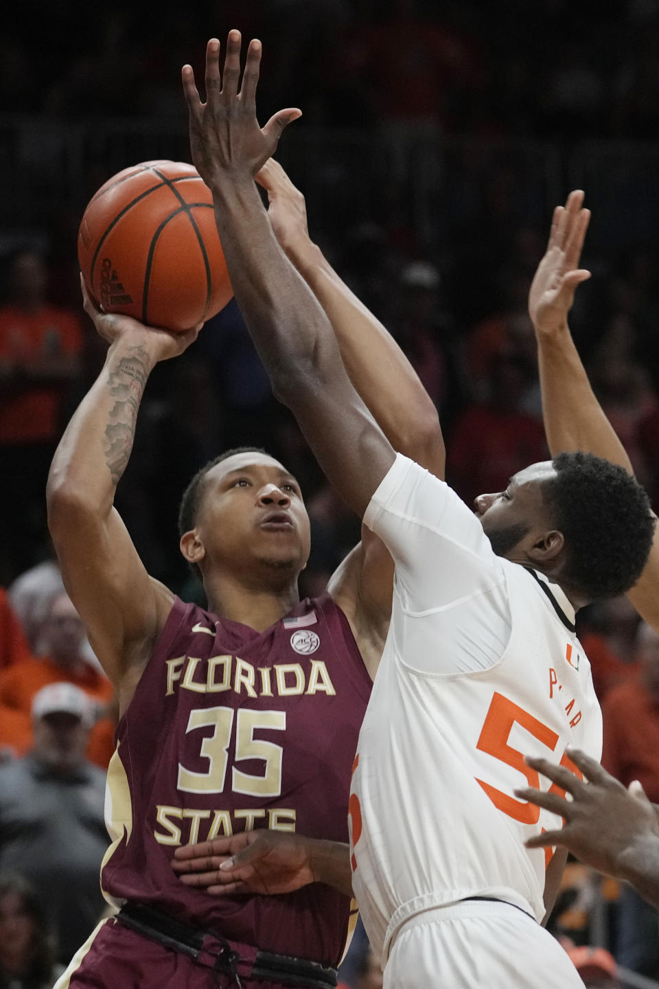 Florida State guard Matthew Cleveland (35) aims for a basket as Miami guard Wooga Poplar (55) defends during the first half of an NCAA college basketball game, Saturday, Feb. 25, 2023, in Coral Gables, Fla. (AP Photo/Marta Lavandier)