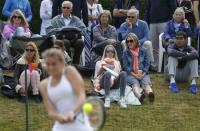 Spectators watch Britain's Katy Dunne serve during her singles match against Ukraine's Anhelina Kalinina during the Wimbledon Tennis Championships qualifying rounds at the Bank of England Sports Centre in Roehampton, southwest London, Britain June 23, 2015. REUTERS/Suzanne Plunkett