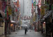 A man walks past on a nearly empty street in a snow fall during a coronavirus disease outbreak in Tokyo