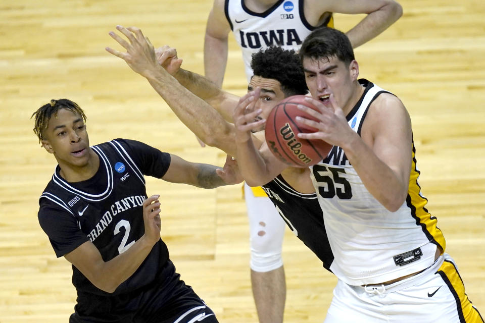 Iowa's Luka Garza (55) bobbles a pass as Grand Canyon's Chance McMillian (2) and Gabe McGlothan defend during the first half of a first round NCAA college basketball tournament game Saturday, March 20, 2021, at the Indiana Farmers Coliseum in Indianapolis. (AP Photo/Charles Rex Arbogast)