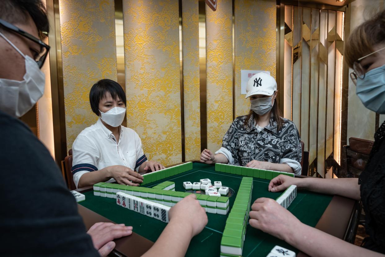 Staff members wearing protective masks demonstrate their safety measures to the media at a mahjong parlor on April 28, 2021, in Hong Kong, China.
