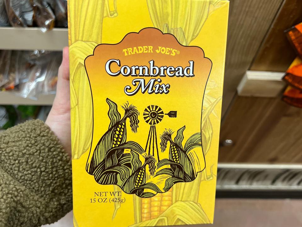 The writer holds a box of Trader Joe's cornbread mix